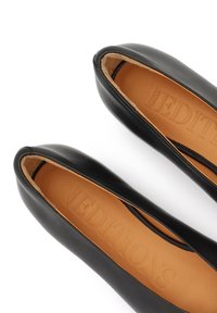 Ballerines en cuir noir avec bout arrondi, finition lisse, et une semelle intérieure beige embossée du mot "EDITIONS". Aucun élément métallique ni motif visible.