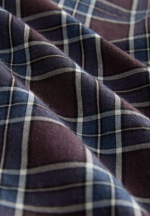 Kariertes Gewebe mit dunkelblauen und burgunderroten Farben und weißen Linien, das eine weiche Textur und ein strukturiertes Muster zeigt.