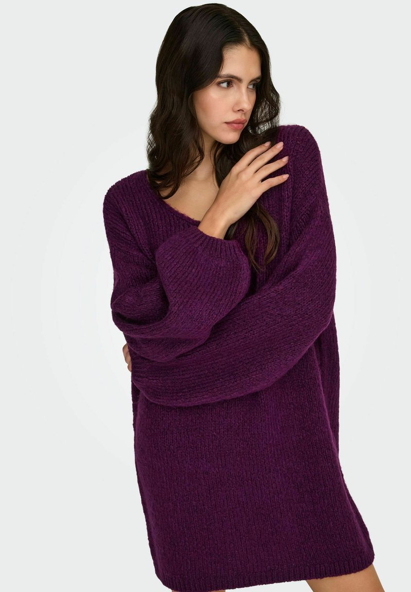 Fioletowy, oversize'owy sweter z dzianiny z dekoltem w serek, teksturowanym splotem, długimi rękawami i luźnym krojem. Odpowiedni do noszenia na co dzień.