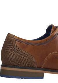 Scarpa in pelle marrone con un pannello laterale testurizzato e decorato, suola blu a contrasto e cucitura blu lungo il bordo del colletto.