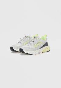Baskets de sport grises avec des accents vert fluo, tissu texturé, semelle rembourrée et lacets élastiques ; présente un logo sur le côté.