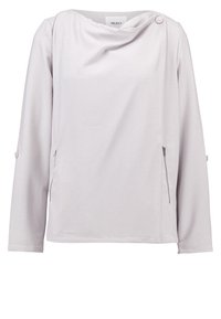 Haut à manches longues gris clair avec un col bénitier drapé, deux fermetures éclair latérales et un accent de bouton sur l'épaule. Tissu texturé.