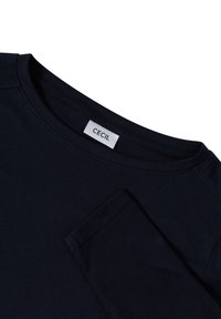 Navy blue short-sleeve T-shirt made of soft cotton, featuring a round neckline and a small pocket detail on the left side. Brand label visible.