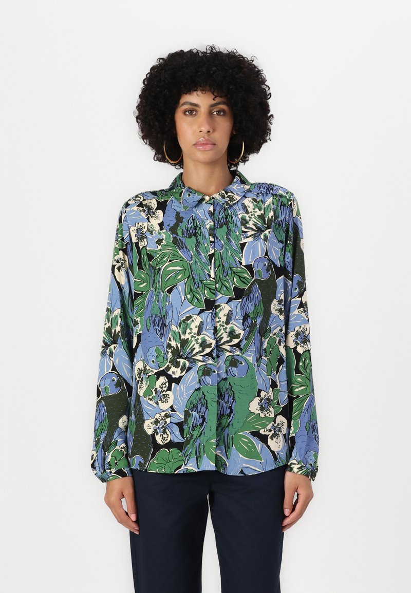Long-sleeved button-up shirt in a multicolored floral and parrot print. Fabric features a smooth texture; colors include green, blue, and black.