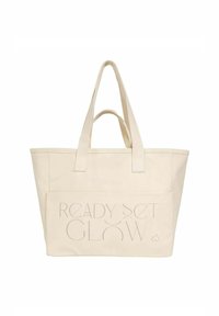Beżowa torba z płótna z dwoma długimi uchwytami, z tekstem "READY SET GLOW" tłoczonym na przedniej kieszeni. Prosta, prostokątna forma.