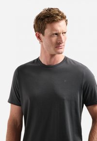 Donkergrijze t-shirt met korte mouwen, gemaakt van zacht materiaal, met een ronde halslijn en een klein logo op de borst. Smooth textuur en klassieke pasvorm.