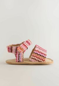 Sandale pour enfant avec des brides en tissu tissé multicolore rose, orange et brun et une semelle beige, vue de côté.