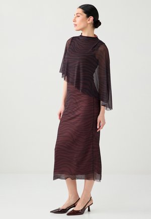 Abito trasparente color vinaccia con stampa zebrata, caratterizzato da maniche a mantella fluttuanti. Abbinato a décolleté lucide con punta a mandorla.