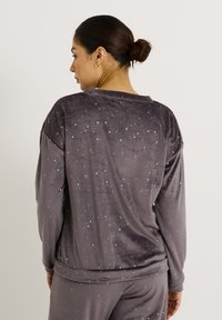 Haut à manches longues gris en velours, décoré d'un motif d'étoiles argentées dispersées. Coupe décontractée avec un col rond et des fentes latérales à l'ourlet.