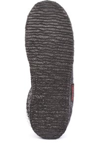 Zwarte rubberen zool met een getextureerde structuur voor grip, voorzien van een rode merklabel aan de zijkant. Ronde vorm met een brede hielbasis.