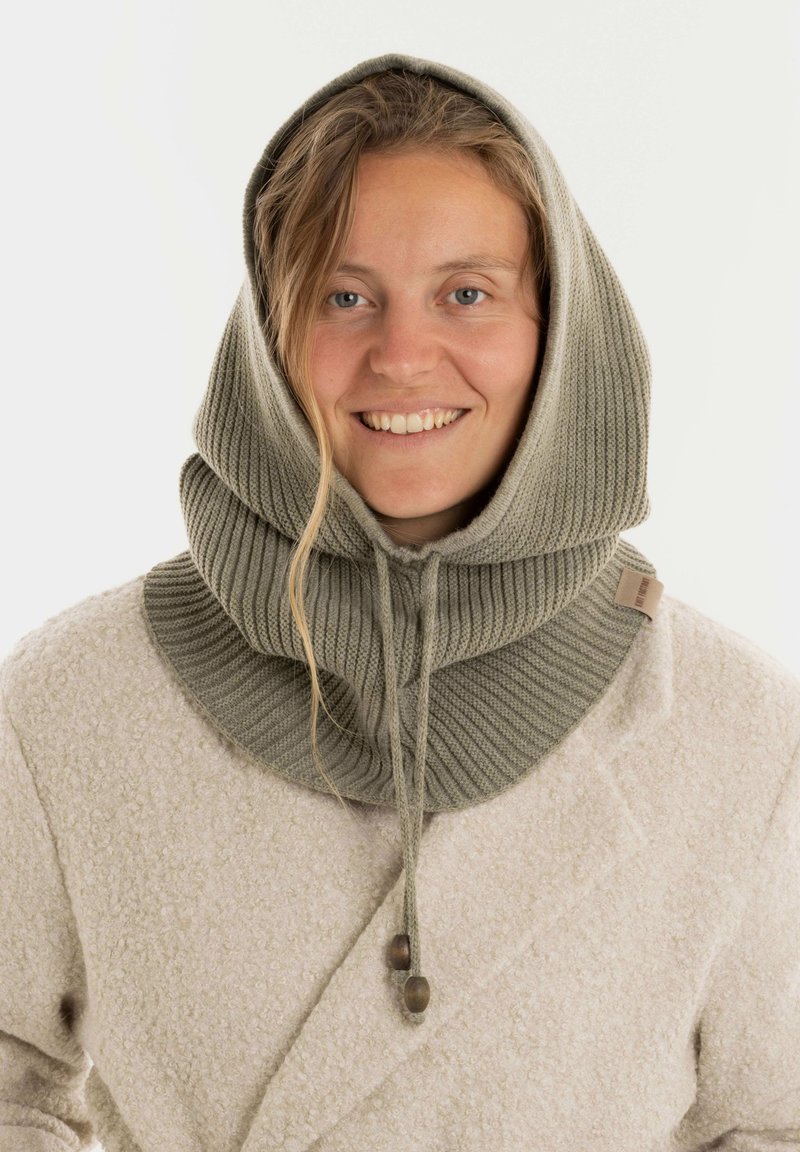 Lichtgrijze gebreide cowl met een capuchonontwerp, voorzien van een ribbelstructuur, verstelbaar trekkoord en houten accenten, gedragen over een beige jas.