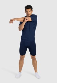 Morski top sportowy i szorty wykonane z elastycznej, odprowadzającej wilgoć tkaniny, z dopasowanym krojem i minimalnymi przeszyciami.