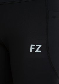 Svarta atletiska tights med en åtsittande design, som har en reflekterande "FZ"-logotyp och texturerade sömmar för extra detalj.