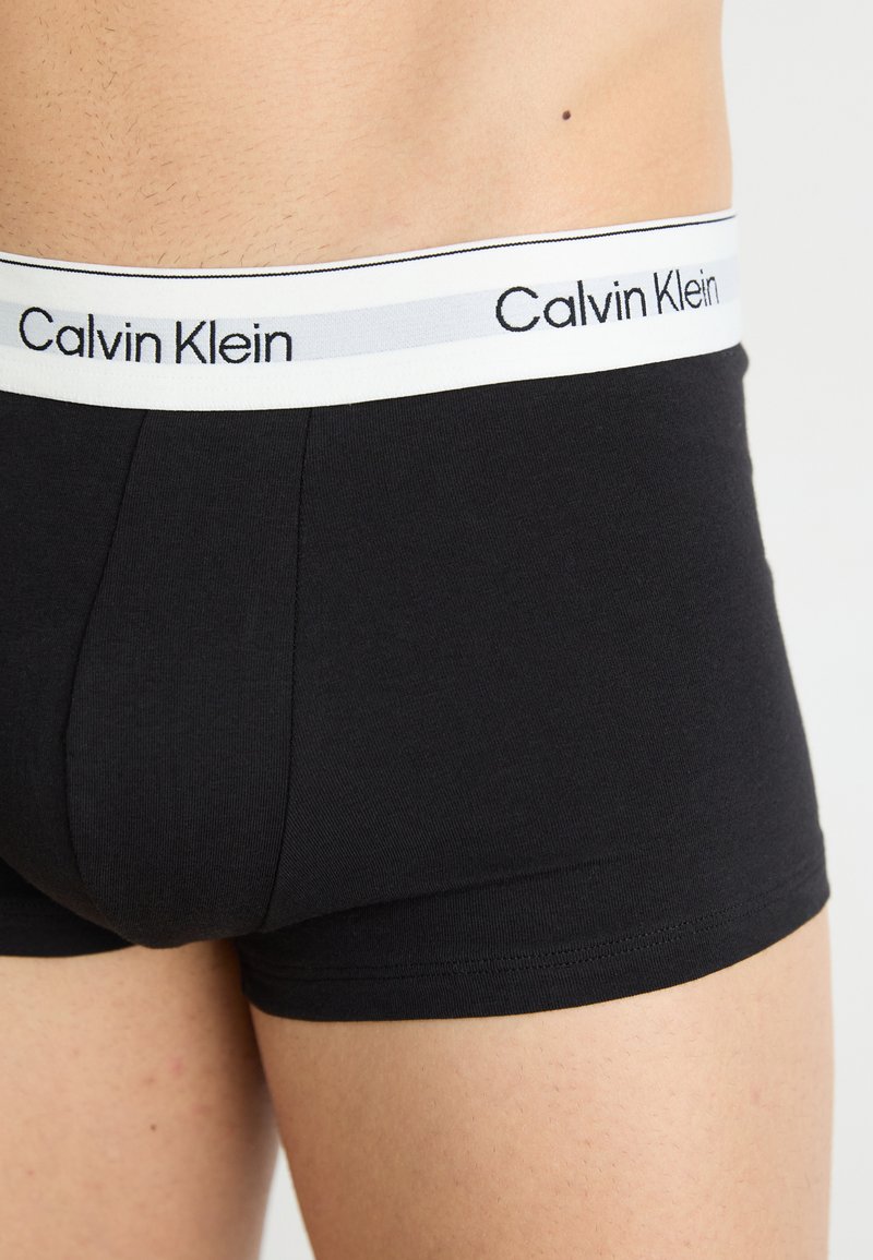 Czarne bawełniane bokserki o dopasowanym kroju. Biała guma w talii z logo "Calvin Klein" w czerni na srebrnym pasku.