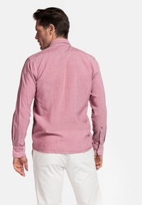 Rode textuur lange mouwen shirt met knoopsluitingen bij de manchetten en een puntige kraag, gestyled met een subtiel gemêleerd patroon. Achteraanzicht weergegeven.