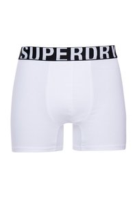 Boxers de algodón blanco con una cinturilla elástica negra que presenta el logo "SUPERDRY" en blanco. Textura suave, diseño ajustado.