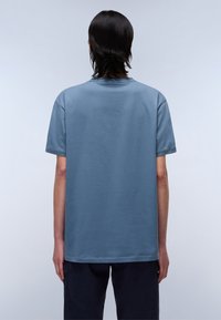 Camiseta de algodón azul con un corte relajado, mangas cortas y cuello redondo. Diseño simple, sin patrones ni gráficos.