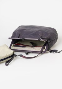Borsa in pelle di un viola scuro con finitura testurizzata, dotata di un interno a righe, accenti rossi e una tracolla a catena removibile. Pochette piccola inclusa.