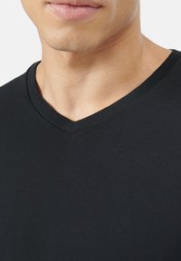 Black V-neck t-shirt made of soft cotton blend, featuring a smooth texture and a simple design without additional patterns or accents.