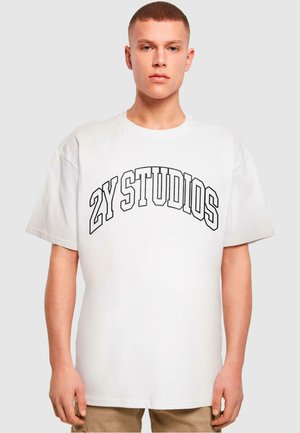 White cotton T-shirt featuring black "2Y STUDIOS" text in an arched design. Short sleeves and loose fit, with a round neckline.