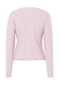 Ροζ ανοιχτόχρωμο μακρυμάνικο πλεκτό τοπ με κάθετα ριμπ μοτ ίβα και κυματιστά τελειώματα στο τελείωμα και τα μανίκια, εμφανίζεται από πίσω.