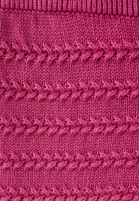 Tissu tricoté rose avec des rangées horizontales de motifs torsadés et une bordure côtelée en haut.