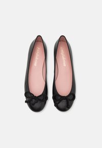 Bailarinas de cuero negras con punta redondeada, plantilla de color rosa suave y un lazo decorativo en la parte delantera. Textura suave y diseño de perfil bajo.