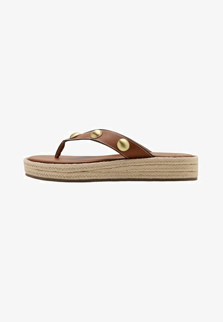 Sandale en cuir marron à lanière avec des clous dorés et une semelle plateforme en jute tressé sur fond blanc.