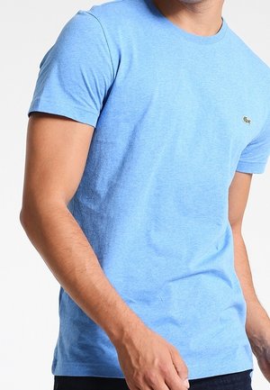 Jasnoniebieska koszulka z krótkim rękawem, wykonana z miękkiej bawełny. Posiada okrągły dekolt i małe logo na lewej piersi.