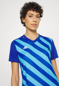 Blau und hellblau gestreiftes Sporttrikot, kurzärmlig, V-Ausschnitt, aus atmungsaktivem Stoff, mit Adidas-Logo auf der Brust.