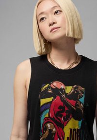 Camiseta sin mangas de algodón negro con un colorido estampado gráfico de un jugador de baloncesto. Cuello redondo y textura suave con colores vibrantes.
