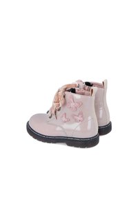 Botas de charol rosa brillante con apliques de mariposa, diseño de cordones y una suela de goma negra duradera.