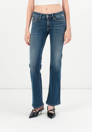 Falmet blå denimjeans med rett ben-design, fem lommer og glidelås. Har subtil søm og en rå kantdetalj nederst.