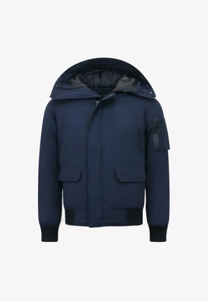 Donkerblauwe gewatteerde jas met capuchon, twee klepzakken aan de voorkant, geribde manchetten en een zak met rits op de linkermouw.