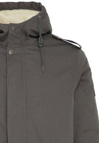 Chaqueta aislante gris con capucha forrada de piel sintética, botones de presión en el frente, cordones ajustables y epaulettes en los hombros. Textura de tela suave.