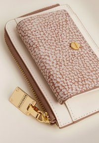 Textured brown and cream wallet featuring a gold snap, zipper closure, and a rectangular shape, highlighting a sophisticated design.