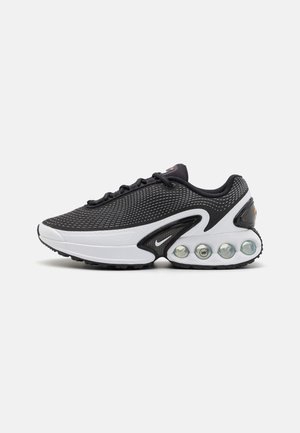 Baskets de sport noires en matériau en maille, avec une semelle intermédiaire blanche et des accents texturés noirs. Présentent des pods de coussin d'air visibles sur le côté.