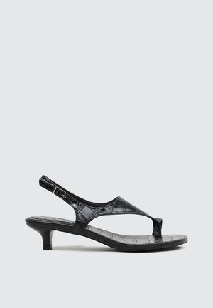 Sandale noire à talon bas avec texture crocodile, bride arrière avec boucle et bout ouvert.