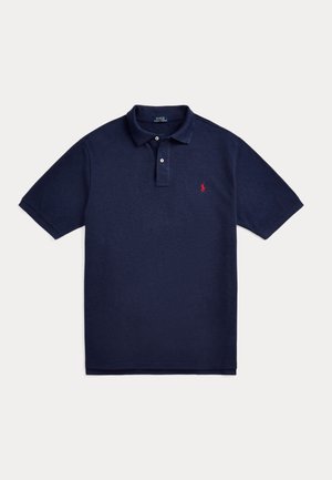 Tmavomodré polo tričko s krátkym rukávom, s límečkovou légou so zapínaním na dva gombíky a malým červeným vyšitým logom na ľavej strane hrudníka.