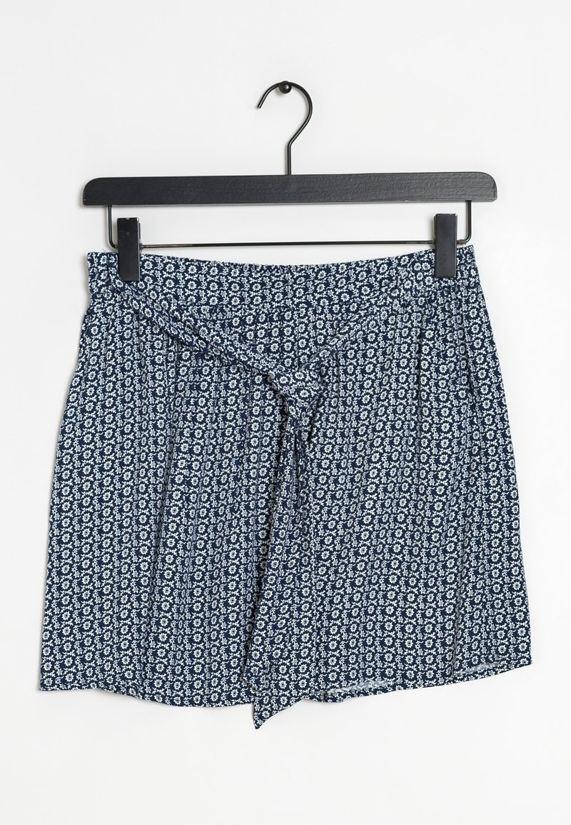 Shorts bleu marine avec un motif floral blanc, dotés d'une taille à nouer et d'une coupe décontractée, suspendus à un crochet noir sur un fond blanc.