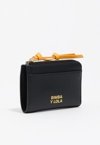 Kompaktowy czarny skórzany portfel z złotym logo "BIMBA Y LOLA", zapinany na zamek z pomarańczowymi skórzanymi uchwytami.