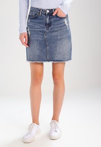 Denimhame, vaaleansininen pesu, risaiset helmat, kuluneet yksityiskohdat, keskipitkä, etutaskut, yhdistetty valkoisten tennareiden kanssa.