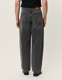 Vysoké nohavice s voľným strihom z šedej džínoviny. Obsahuje dve zadné vrecká a koženú nášivku značky na páse.