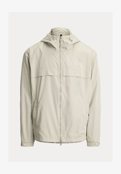 Veste à capuche beige clair avec fermeture éclair à l'avant, cordons ajustables sur la capuche, manches longues avec poignets à boutons-pression et poches latérales.