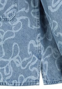 Denimstoff in Hellblau mit einem wellenförmigen Muster in einem etwas dunkleren Blau. Enthält eine Taschendetail und einen ausgefransten Saum.