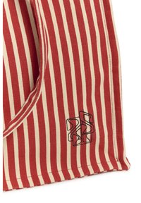 Raudonos ir smėlio spalvos vertikalios juostelės audinys su juodu abstrakčiu geometriniu siuvinėjimu prie apatinio krašto.