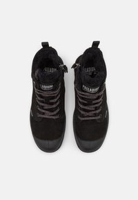 Black suede ankle boots with a textured tongue, contrasting laces, and rubber toe cap. Fleece lining and "Palladium" branding on the tongue.