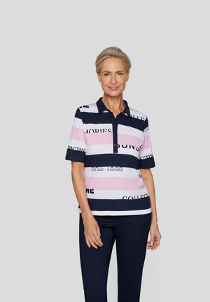 Poloshirt mit Kragen im gestreiften Muster, das Rosa, Weiß und Marineblau enthält. Textdrucke sind über die Streifen verteilt. Kurze Ärmel.