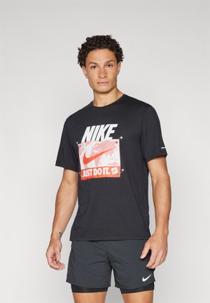 Schwarzes Baumwoll-T-Shirt mit einem großen weißen und roten "NIKE"-Logo und einer zentralen Globusgrafik, Kurzarm und Rundhalsausschnitt.