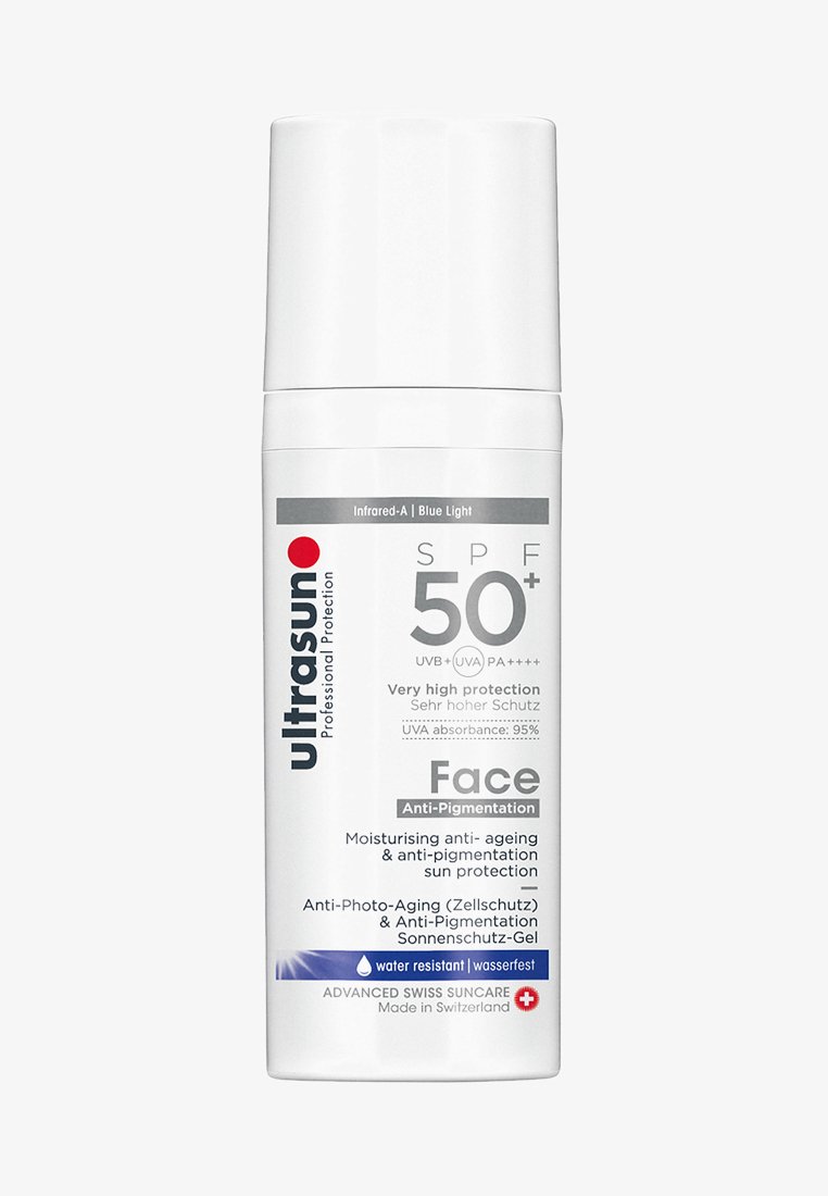 Witte plastic fles met SPF 50+ zonnebrandcrème voor het gezicht, met een rood logo, grijze tekst en een waterbestendige sticker. Stofdop met pomp.